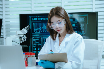 A scientist in a laboratory conducts a medical experiment with a red liquid in a test tube,...