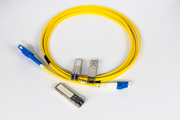 Yellow coiled fiber optic patch cord with blue connectors SFP modules are essential for high-speed...