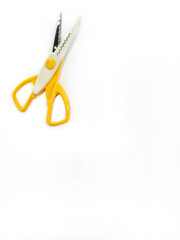 Zigzag wavy pattern scissors on a white background. Yellow creative scissors with serrated blades for decorative cutting. Scissors for crafts, card, scrapbooking and other DIY projects. Free space.