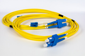 Bright yellow fiber optic patch cords, neatly wrapped, are displayed on a clean white background.