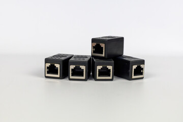 Neatly arranged five black RJ45 Ethernet extender connectors on a clean white background.