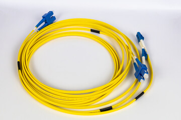 Bright yellow fiber optic patch cords, neatly wrapped, are displayed on a clean white background.