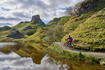 active woman riding her electric mountain bike in the spectacular volcabinic landscape of Glen...
