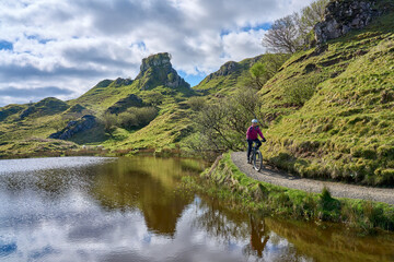 active woman riding her electric mountain bike in the spectacular volcabinic landscape of Glen...