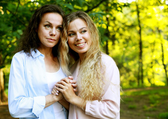 portrait of mother and daughter hugging, summer time, park