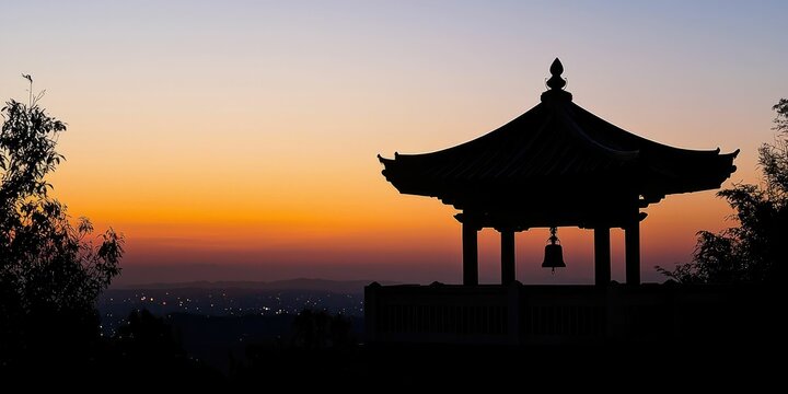 A temple bell tower silhouetted at twilight