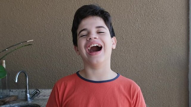 12 year old Brazilian teenager staring at the camera and laughing.