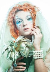 Young beautiful redhead woman with bright creative make-up in New Year's style. Snow queen, fairy. Close-up portrait.