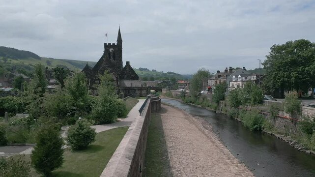 Drone footage of River Calder and St Michael's Parish Church on a sunny day in Mytholmroyd, England