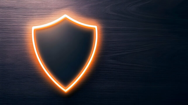 A sleek black shield with an illuminated orange outline against a dark wooden background, symbolizing protection and security