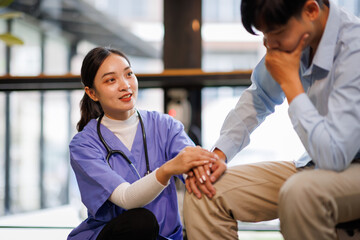 Female nurse hold her man patient's hand. Concept of giving Support. 
