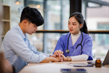 Compassionate Asian Nurse Offering Comfort by Connecting Hands at a Healthcare Facility 
