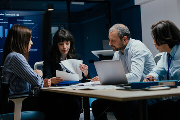 Business executives and assistants brainstorming investment risk evaluation in corporate boardroom