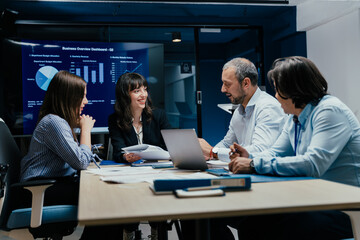 Business executives and assistants brainstorming investment risk evaluation in corporate boardroom