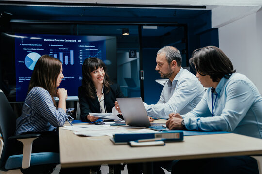 Business executives and assistants brainstorming investment risk evaluation in corporate boardroom