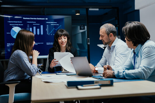 Business executives and assistants brainstorming investment risk evaluation in corporate boardroom