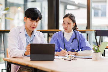 Obraz premium A Doctors and female nurse cooperating while working on laptop in the office. 