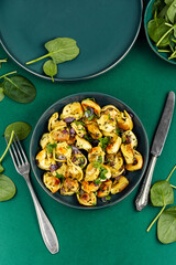 Cooked spinach dumplings in bowl.