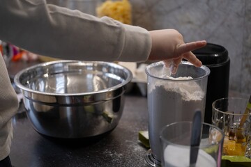 Child Sprinkling Flour for Baking Preparation in Home Kitchen