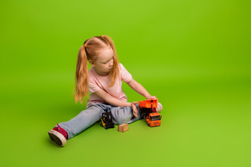Young girl with pigtails plays with toy trucks in bright setting, expressing childhood imagination...