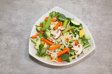 Uncooked vegetables medley in a white bowl for stir-fry.