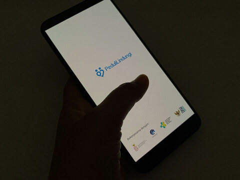 Bekasi, Indonesia - March 22nd 2025: splash screen of PeduliLindungi app on android smartphone. Covid-19 tracing app from Indonesian government