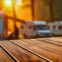 Empty wooden table with copy space, camping trailers and trees in the background. Vacation vibes, outdoor travel and product placement concept. Peaceful outdoor lifestyle, travel-friendly atmosphere.