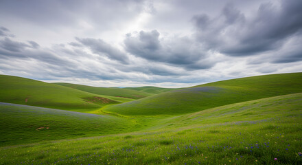 Obraz premium Rolling green hills with dramatic cloud cover