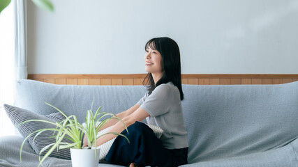 リビングのソファに座る笑顔の女性