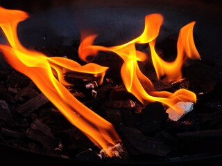 A pile of charcoal with a fire burning on top