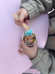 Child Eating Ice Cream with Sprinkles from Paper Cup