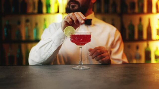 Male bartender secretly drugging guest's drink and serving it, criminal behavior