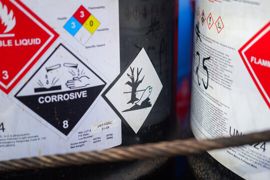 Acidity corrosion or skin burn hazard, safety sign on the chemical containment barrel. Sign and symbol for industrial product, close-up.