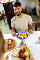 Young Man Enjoying Scrambled Eggs and Vegetables for Breakfast