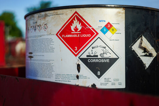 Acidity corrosion or skin burn hazard, safety sign on the chemical containment barrel. Sign and symbol for industrial product, close-up.