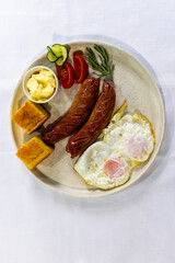 Fried Egg with Sausages and Fresh Sides on Plate