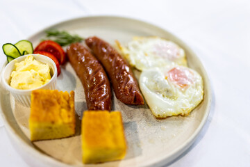Fried Egg with Sausages and Fresh Sides on Plate