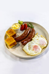 Fried Egg with Sausages and Fresh Sides on Plate