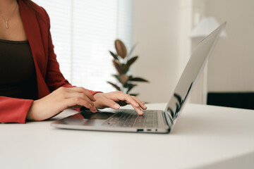 Close-up portrait typing keyboard on laptop computer. Working online on white table at office....
