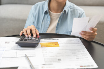 Debt concept stressed asian young business woman using calculator to calculate expenses of monthly,...