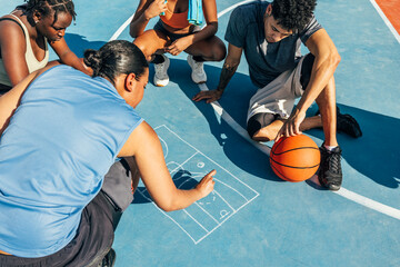Group discussing basketball strategy on outdoor court