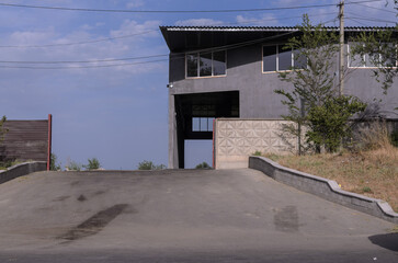 paved entrance to an industrial building against a blue sky background