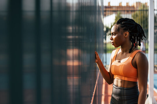 Black woman contemplating outdoors in athletic wear
