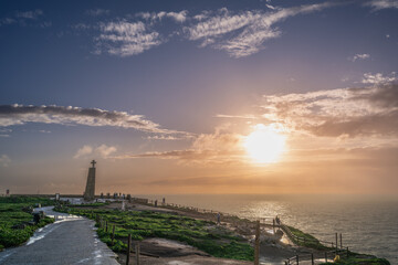 Stunning sunset at Cabo de Roca featuring a cross monument and ocean view. Ideal for travel and...