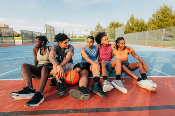 Group of friends relaxing on a basketball court