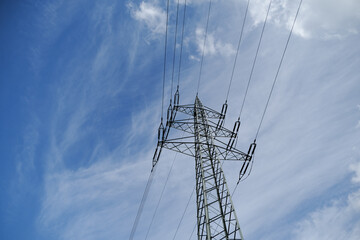 A tall power tower is seen against a blue sky