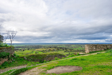 Panoramic view of Trujillo Spain showcasing ancient stone walls and a lush green valley under a...