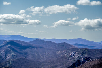 Fototapeta premium A valley with mountains in a haze and clouds in the sky.