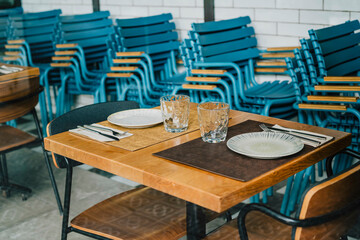 Empty restaurant table setup with stacked blue chairs
