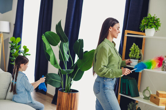Mother and daughter cleaning their cozy home together, demonstrating family bonding and teamwork